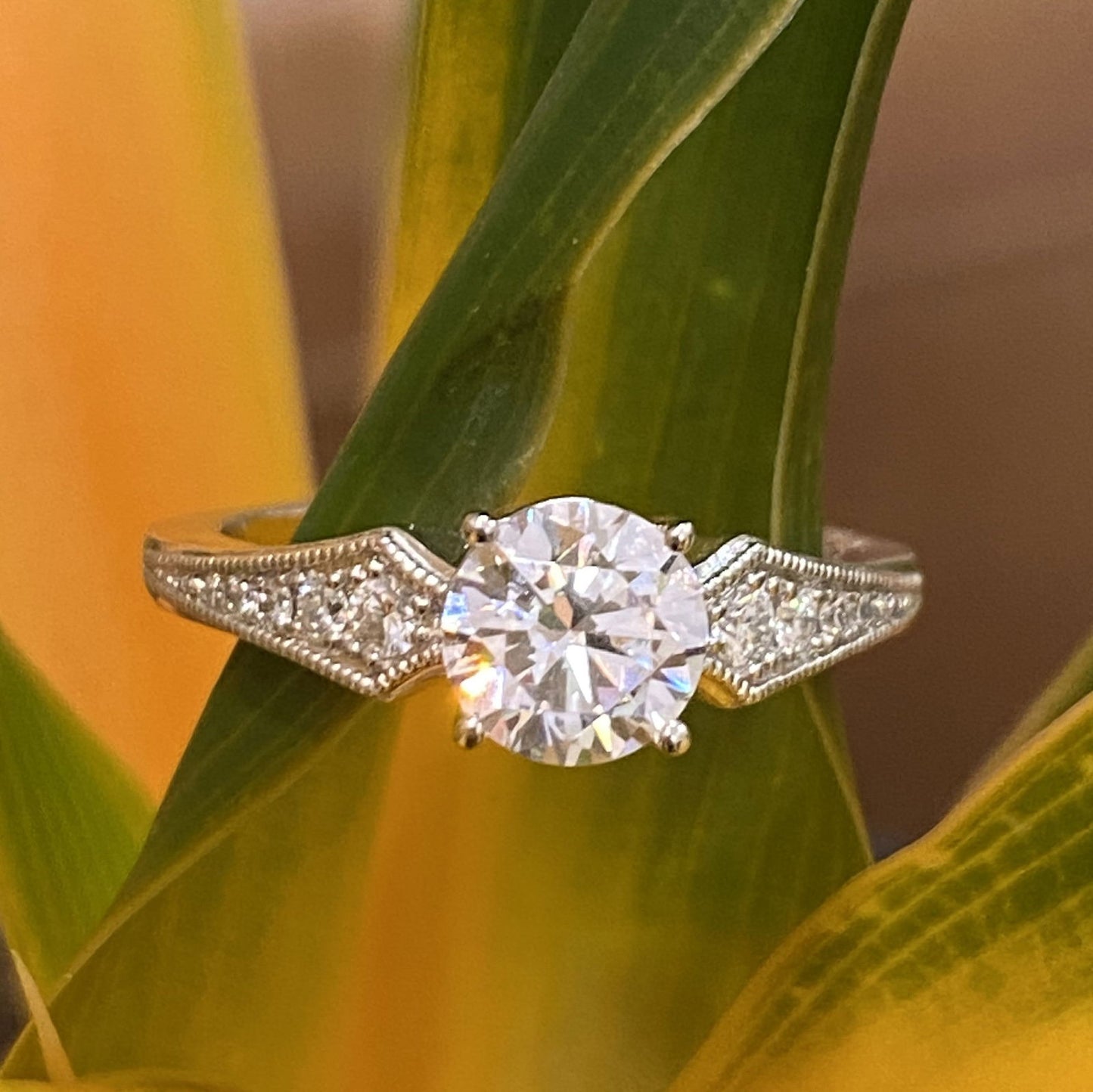 Photo of "Grace" Deco Milgrain Engagement Ring in a decorative scene, designed by , available at Plumb Gold & Plumb Silver