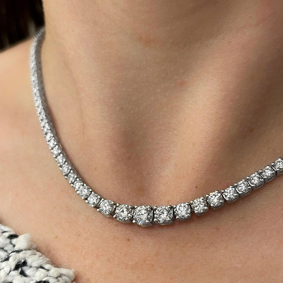 Photo of Graduated Diamond Tennis Necklace in a decorative scene, designed by , available at Plumb Gold & Plumb Silver
