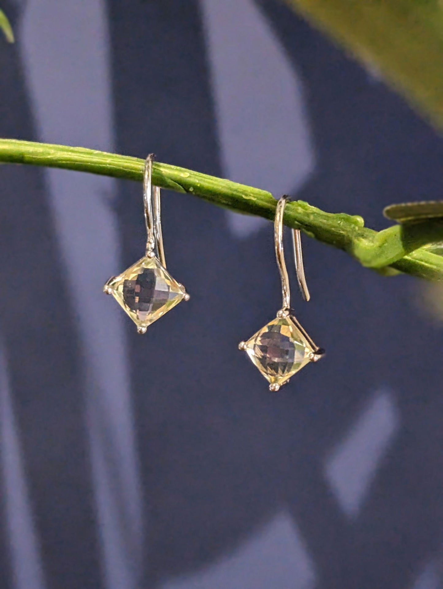 Photo of Green Quartz Drop Earrings in a decorative scene, designed by , available at Plumb Gold & Plumb Silver