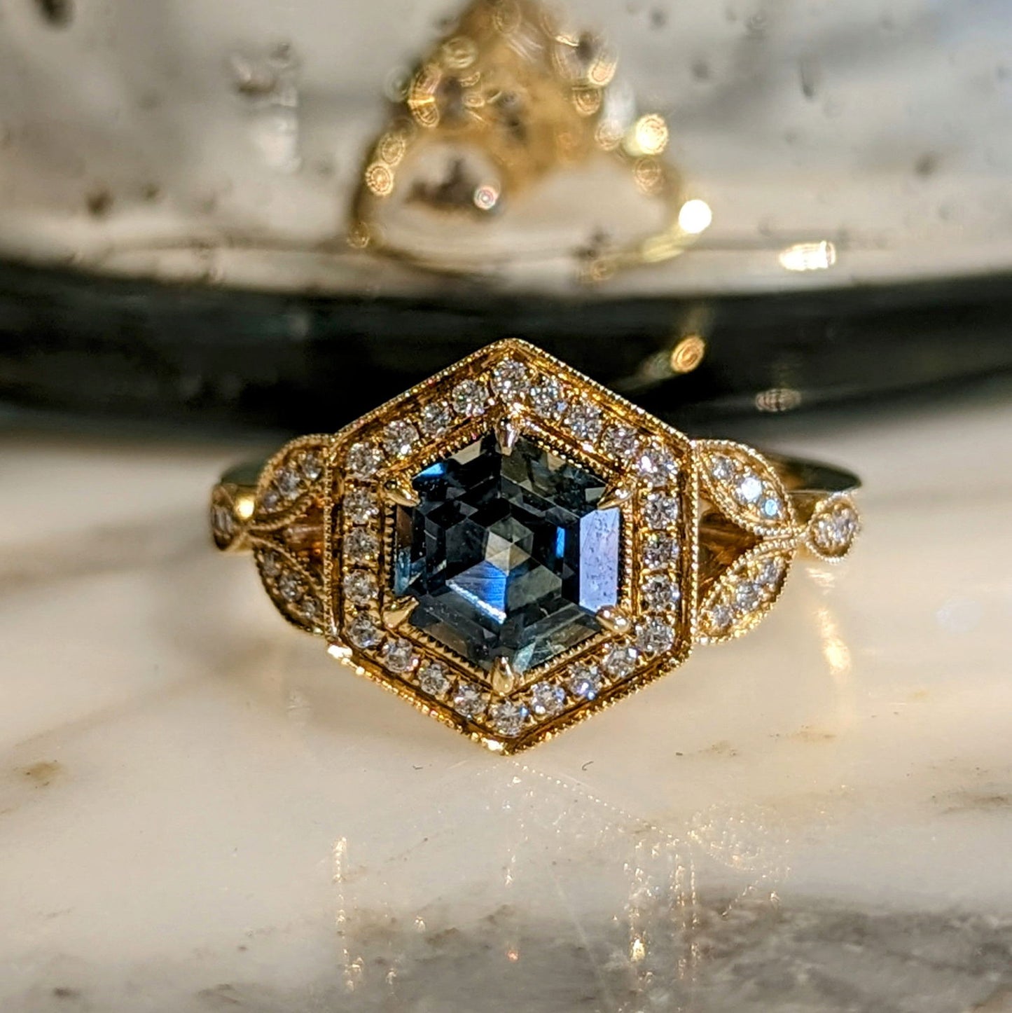 Photo of Green Sapphire hexagon Ring in a decorative scene, designed by , available at Plumb Gold & Plumb Silver