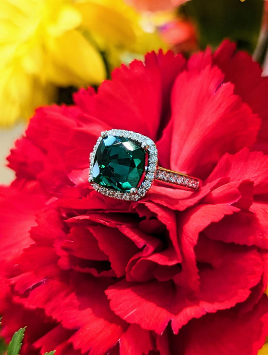 Photo of Green Tourmaline Halo Ring in a decorative scene, designed by , available at Plumb Gold & Plumb Silver