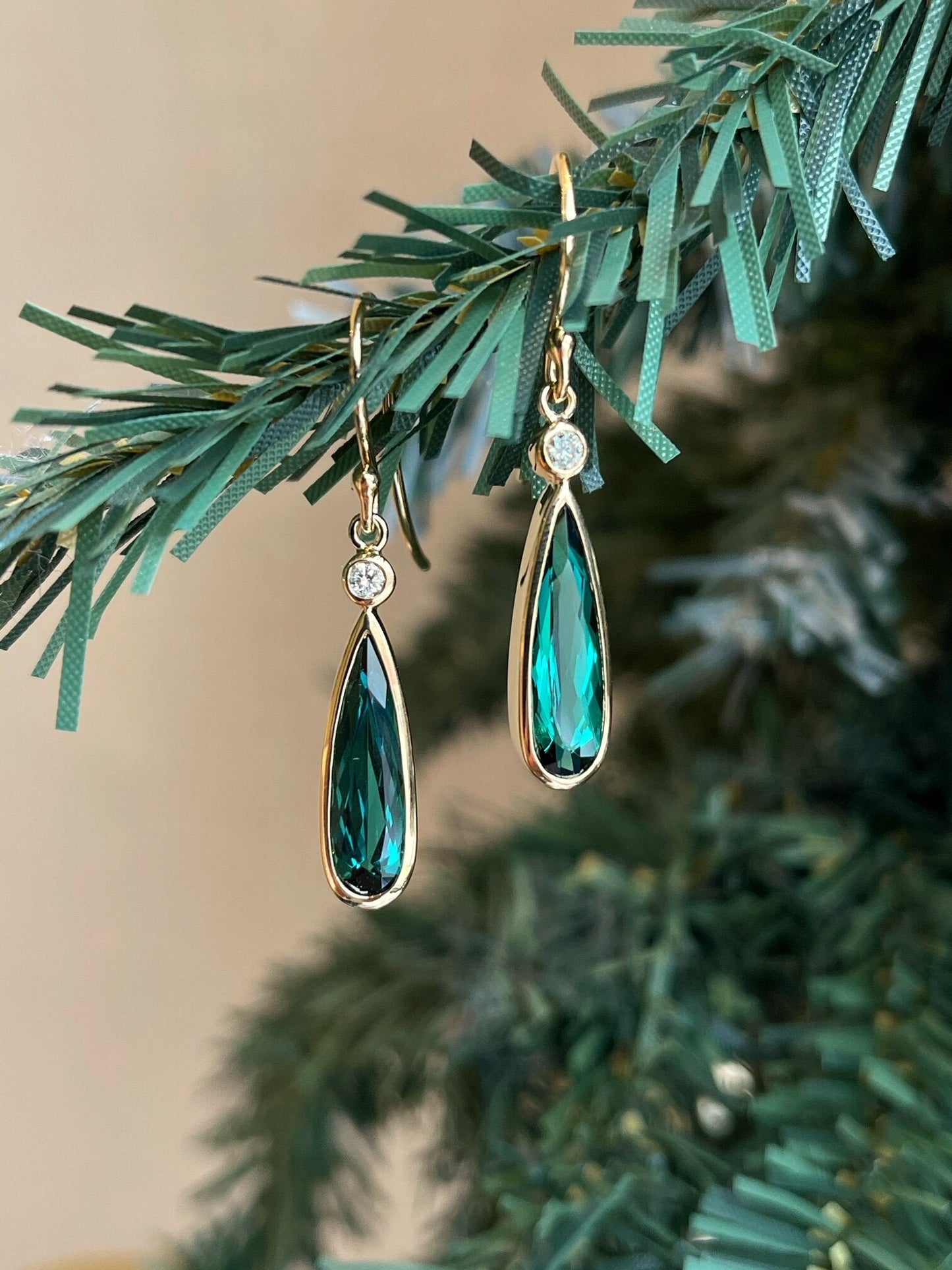 Photo of Green Tourmaline and Diamond Dangles in a decorative scene, designed by , available at Plumb Gold & Plumb Silver