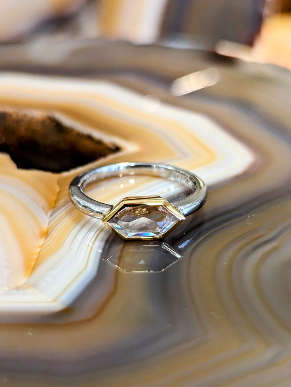 Photo of Hexagon Bezel Ring in a decorative scene, designed by , available at Plumb Gold & Plumb Silver
