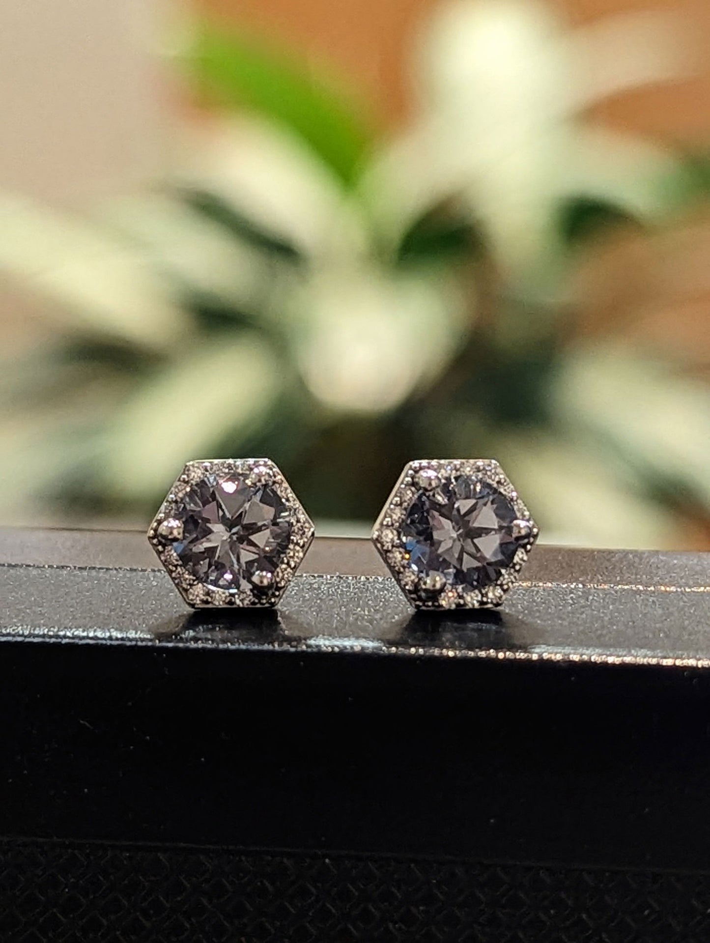 Photo of Hexagon Grey Spinel Studs in a decorative scene, designed by , available at Plumb Gold & Plumb Silver