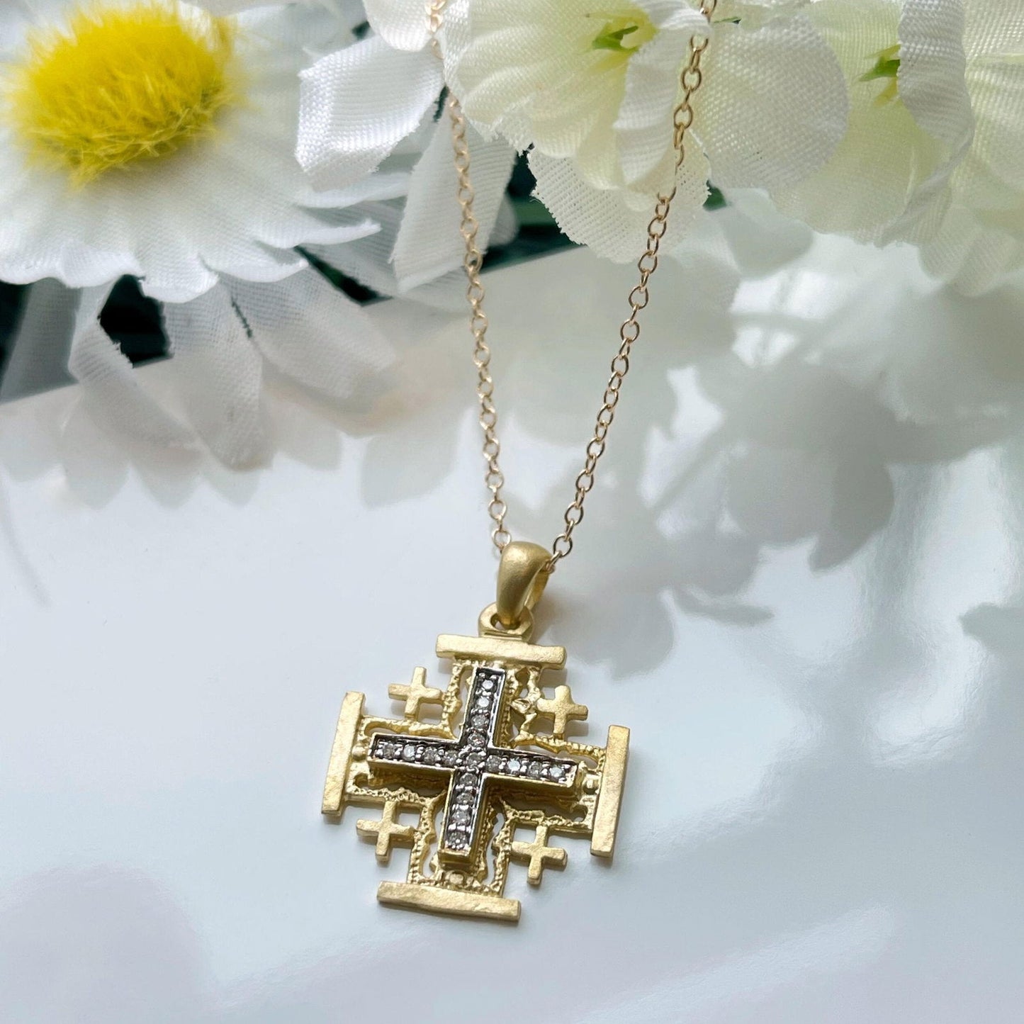 Photo of I.Reiss Diamond Jerusalem Cross Pendant in a decorative scene, designed by , available at Plumb Gold & Plumb Silver