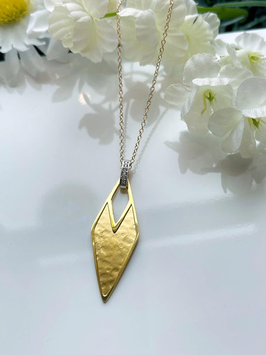 Photo of I.Reiss Paper Kite Necklace in a decorative scene, designed by , available at Plumb Gold & Plumb Silver