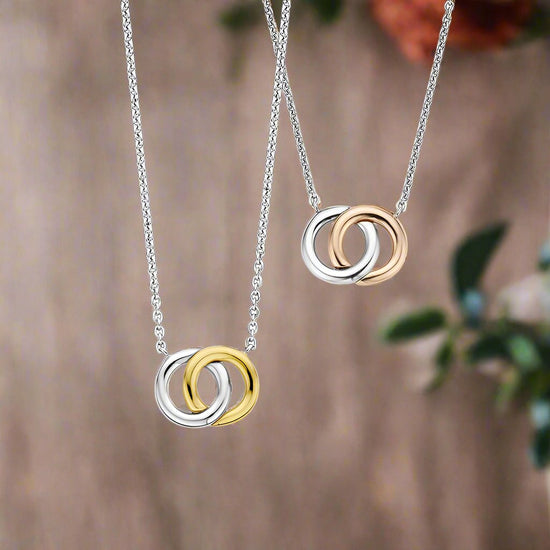 Photo of Interlocking Circles Necklace in a decorative scene, designed by -, available at Plumb Gold & Plumb Silver