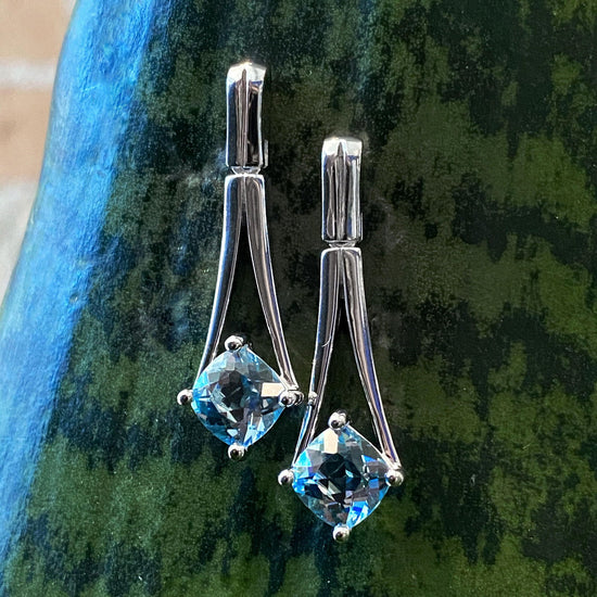 Photo of Jointed "V" Dangles with Blue Topaz in a decorative scene, designed by , available at Plumb Gold & Plumb Silver