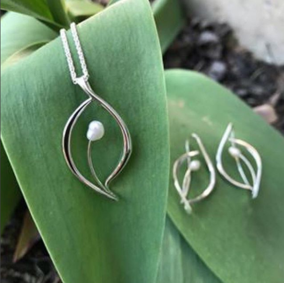 Photo of "Jonquil" Necklace in a decorative scene, designed by , available at Plumb Gold & Plumb Silver