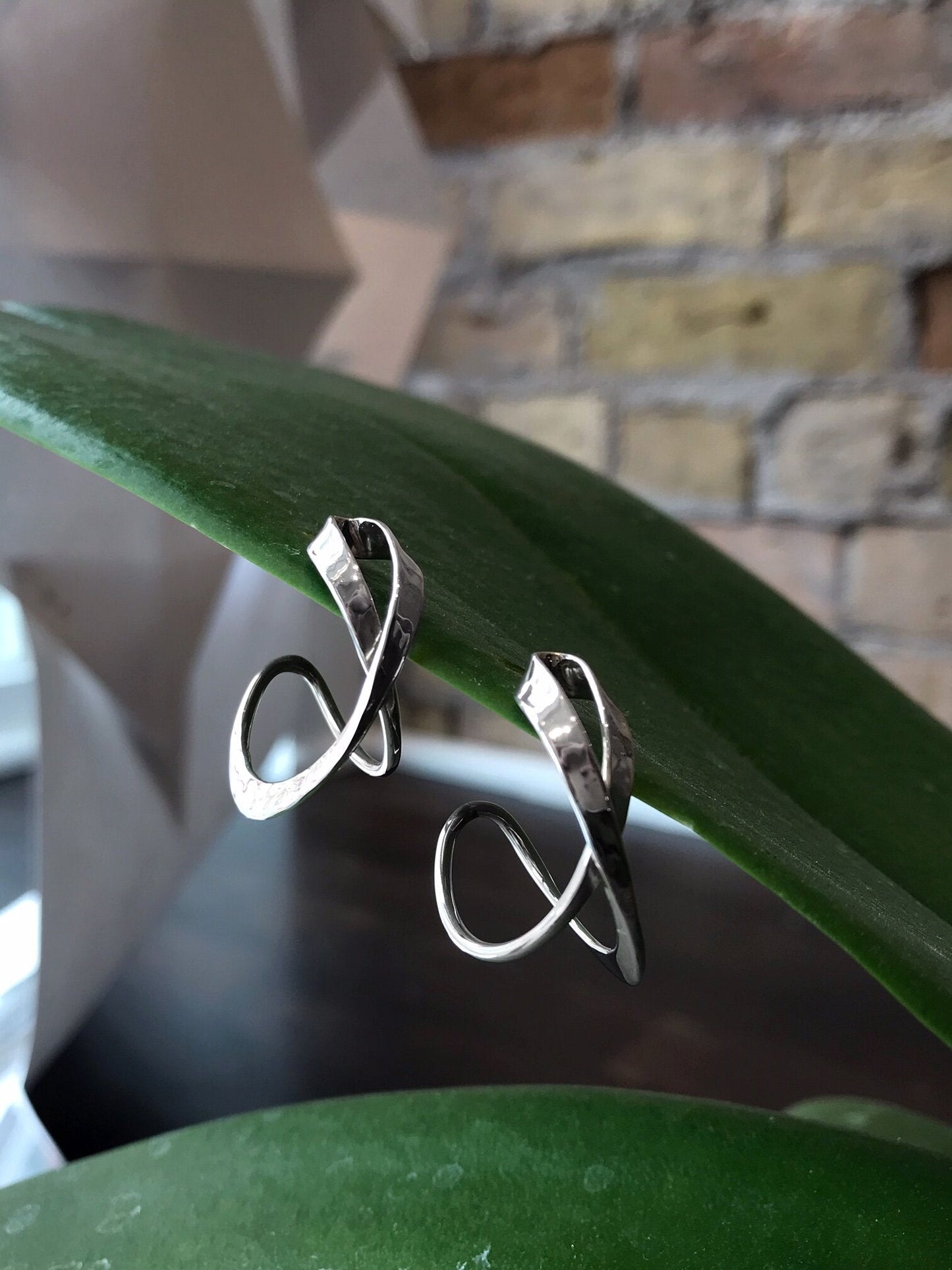 Photo of "Joy" Earrings in a decorative scene, designed by , available at Plumb Gold & Plumb Silver
