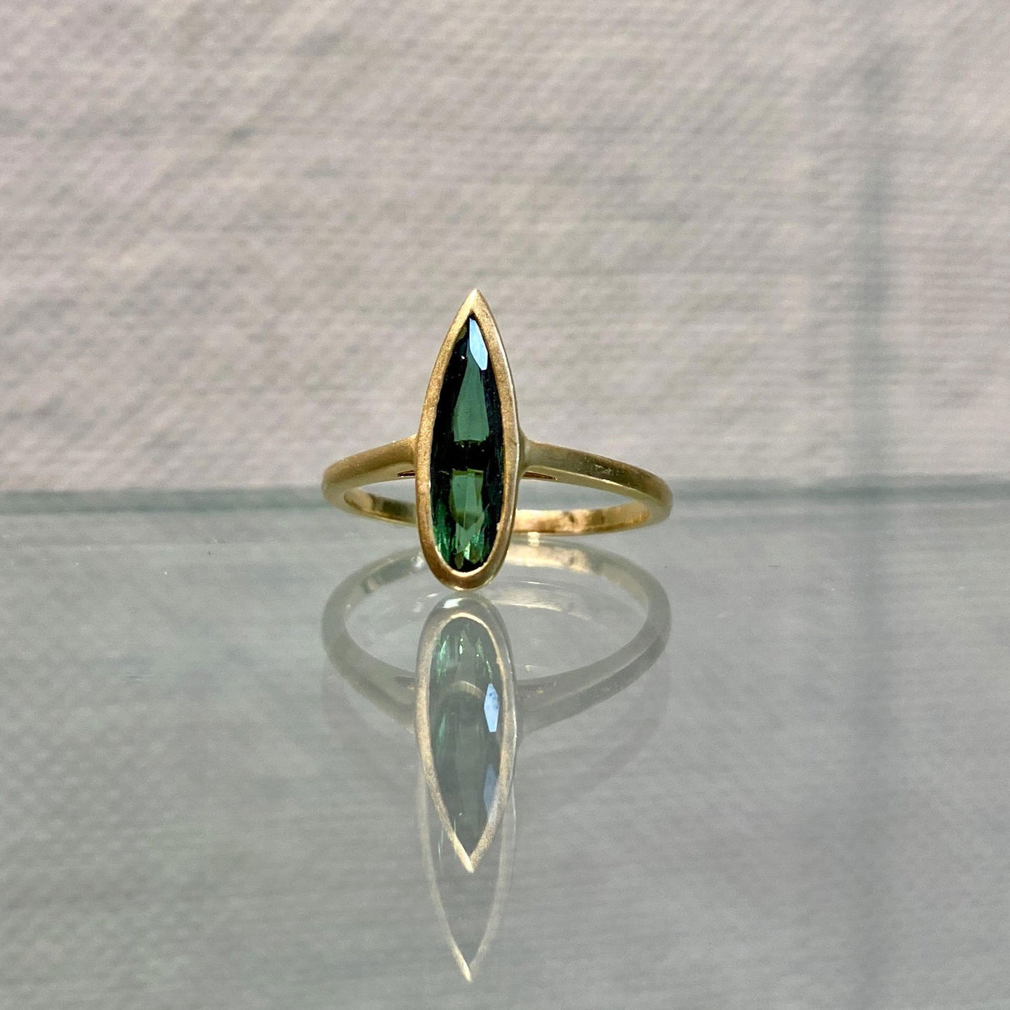 Photo of Kim Collins Green Tourmaline Spike Ring in a decorative scene, designed by , available at Plumb Gold & Plumb Silver