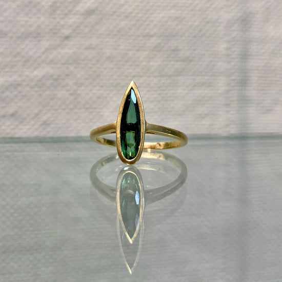 Photo of Kim Collins Green Tourmaline Spike Ring in a decorative scene, designed by , available at Plumb Gold & Plumb Silver