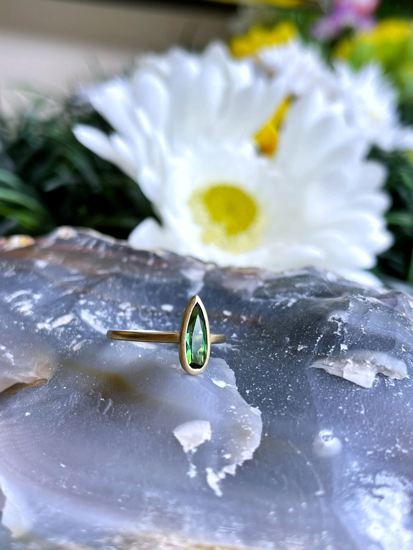 Photo of Kim Collins Green Tourmaline Yumdrop in a decorative scene, designed by , available at Plumb Gold & Plumb Silver