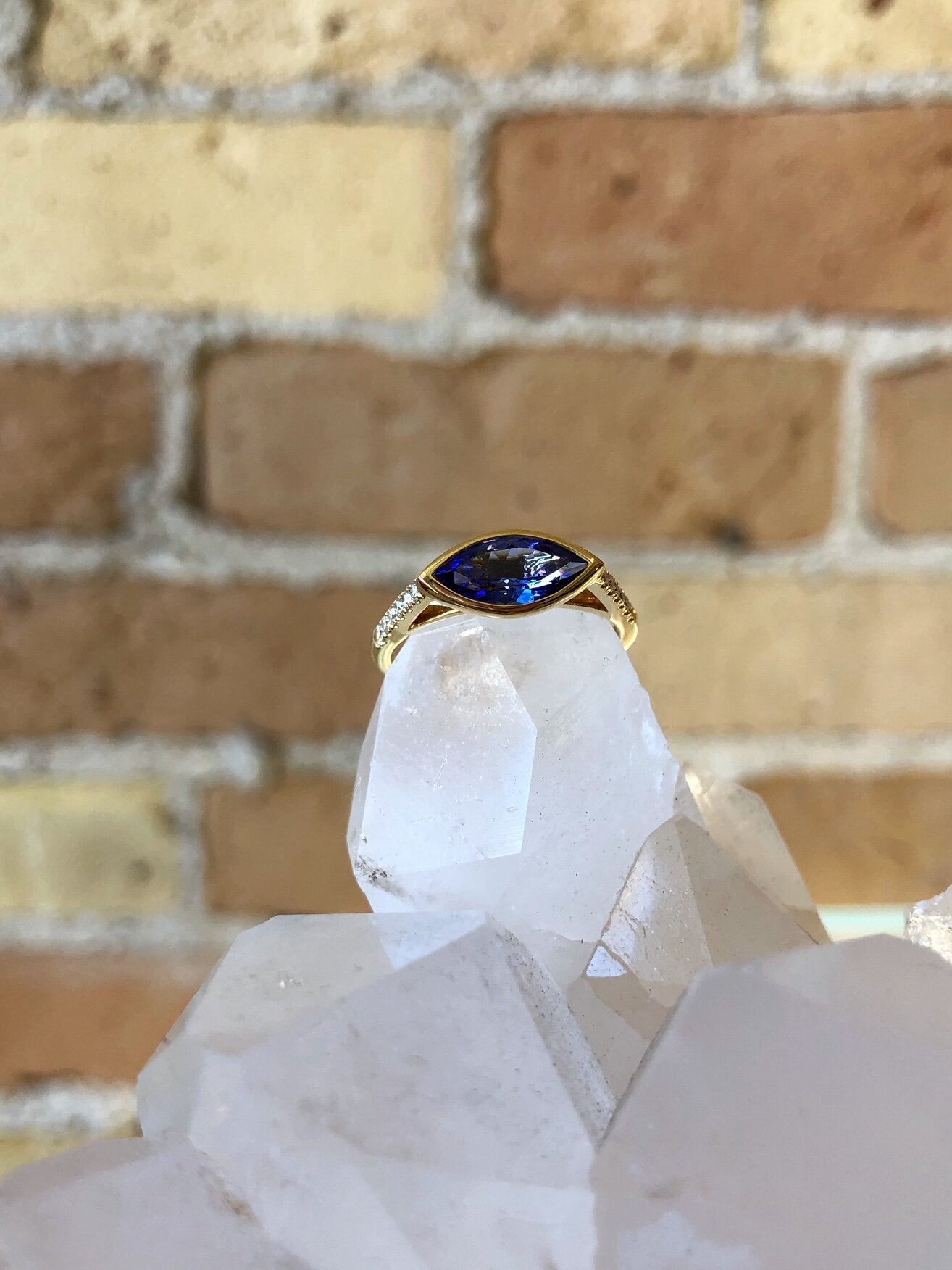 Photo of Kim Collins Marquise Tanzanite Stacker Ring in a decorative scene, designed by , available at Plumb Gold & Plumb Silver