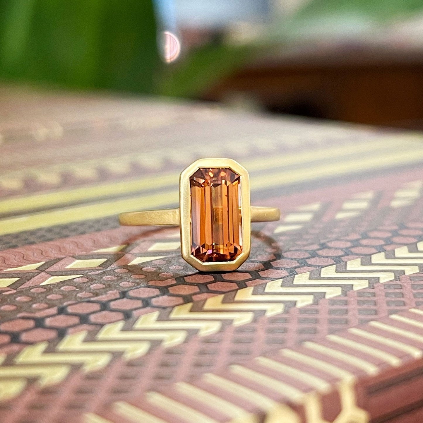 Photo of Kim Collins Spice Zircon Ring in a decorative scene, designed by , available at Plumb Gold & Plumb Silver