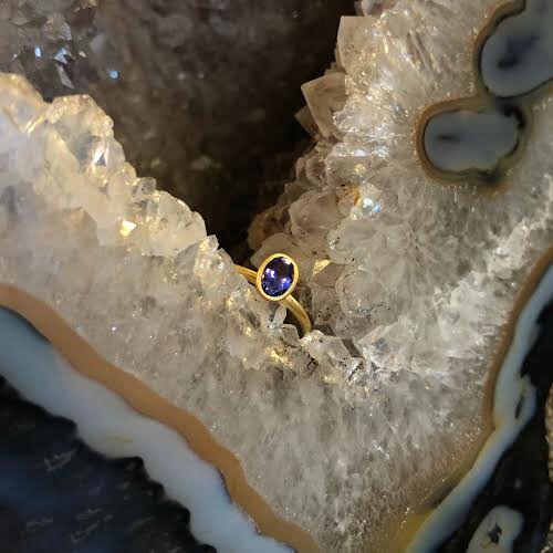 Photo of Kim Collins Tanzanite Yum Drop in a decorative scene, designed by , available at Plumb Gold & Plumb Silver