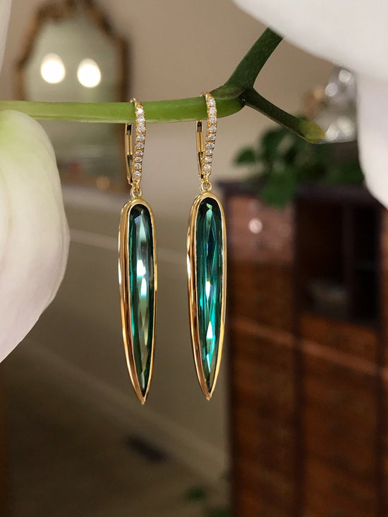 Photo of Kimberly Collins Green Tourmaline "Spike" Dangle in a decorative scene, designed by , available at Plumb Gold & Plumb Silver