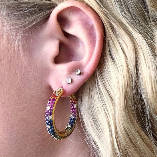 Photo of Kimberly Collins Rainbow Sapphire Hoops in a decorative scene, designed by , available at Plumb Gold & Plumb Silver
