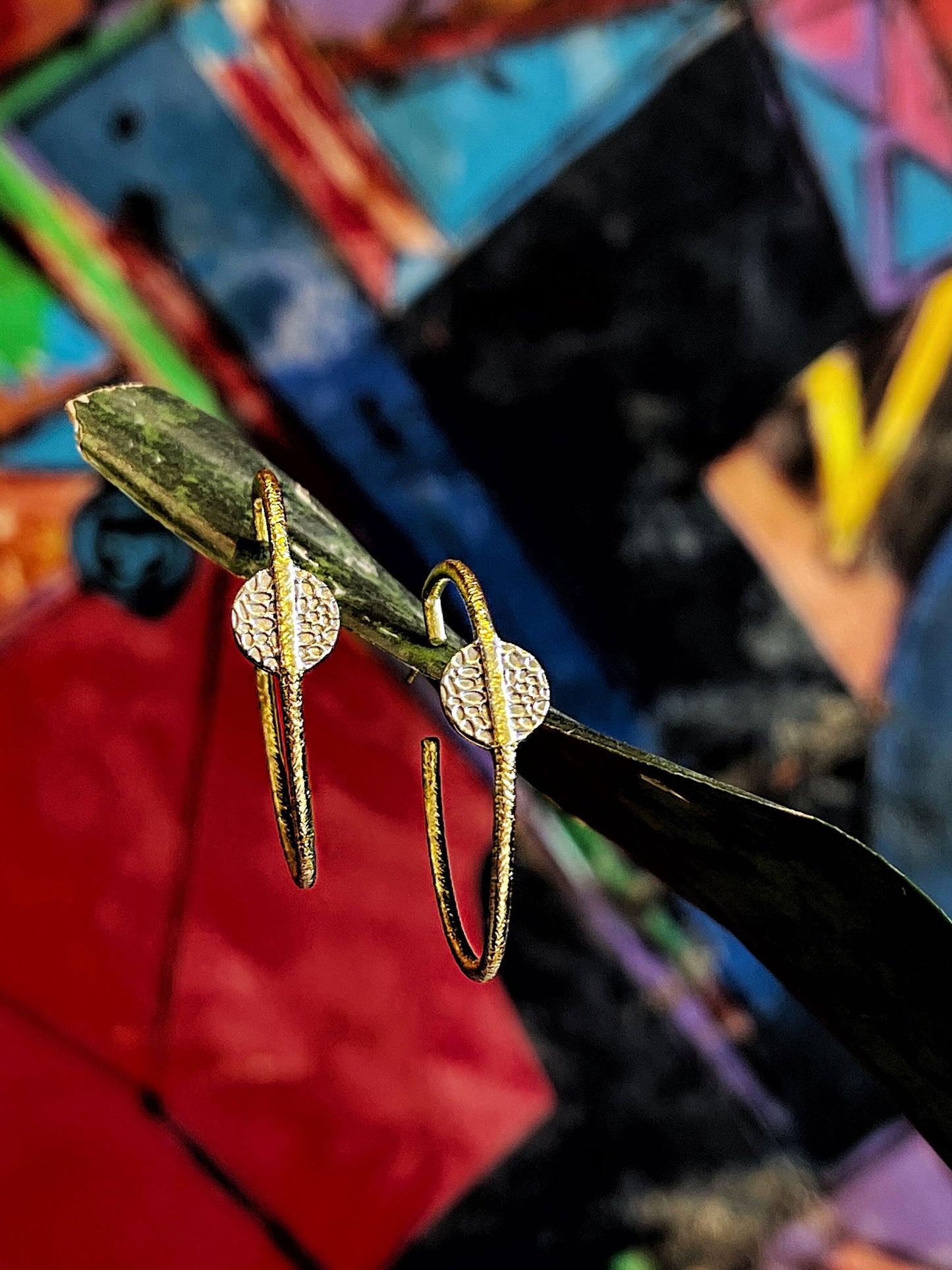 Photo of "Kymbal" Hoop Earrings in a decorative scene, designed by , available at Plumb Gold & Plumb Silver