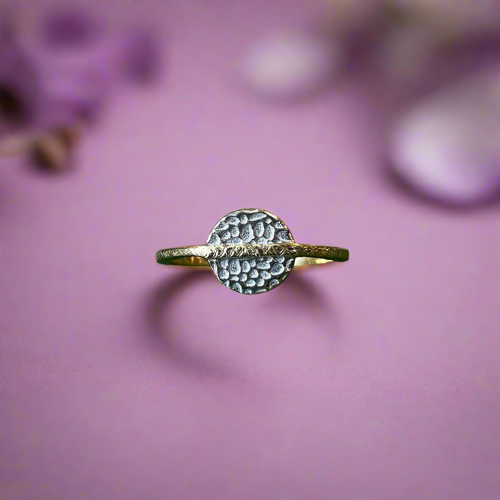 Photo of “Kymbal” Ring in a decorative scene, designed by , available at Plumb Gold & Plumb Silver
