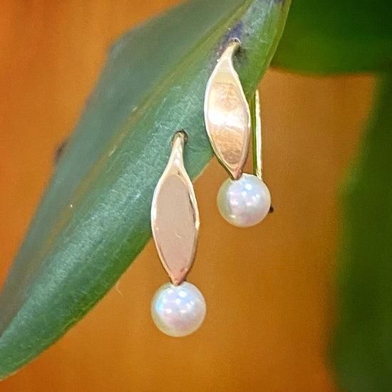 Photo of Le Petite Pearl Earring in a decorative scene, designed by , available at Plumb Gold & Plumb Silver