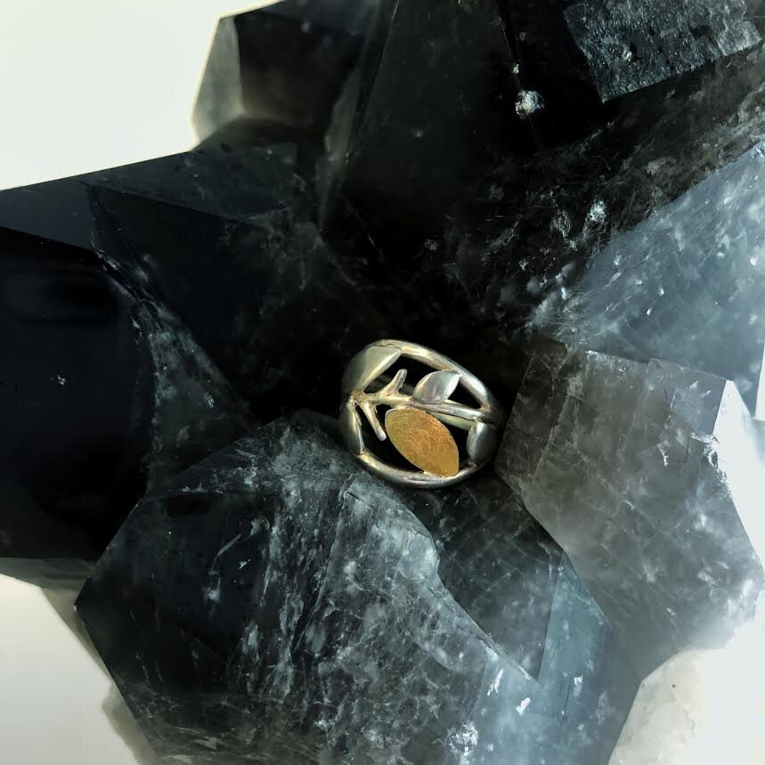 Photo of Leafy Branch Ring in a decorative scene, designed by , available at Plumb Gold & Plumb Silver
