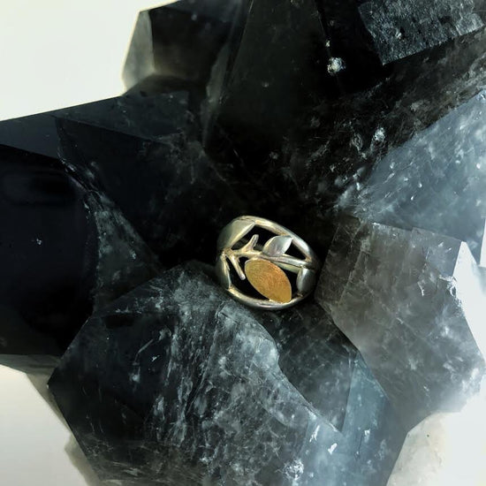 Photo of Leafy Branch Ring in a decorative scene, designed by , available at Plumb Gold & Plumb Silver