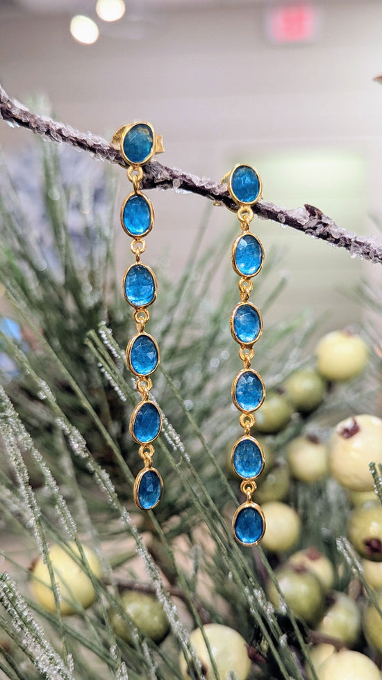 Photo of Long Apatite Earrings in a decorative scene, designed by , available at Plumb Gold & Plumb Silver