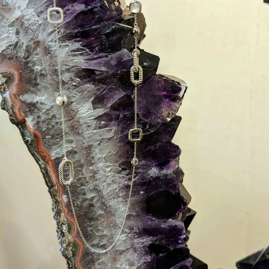 Photo of Long Station Necklace in a decorative scene, designed by , available at Plumb Gold & Plumb Silver