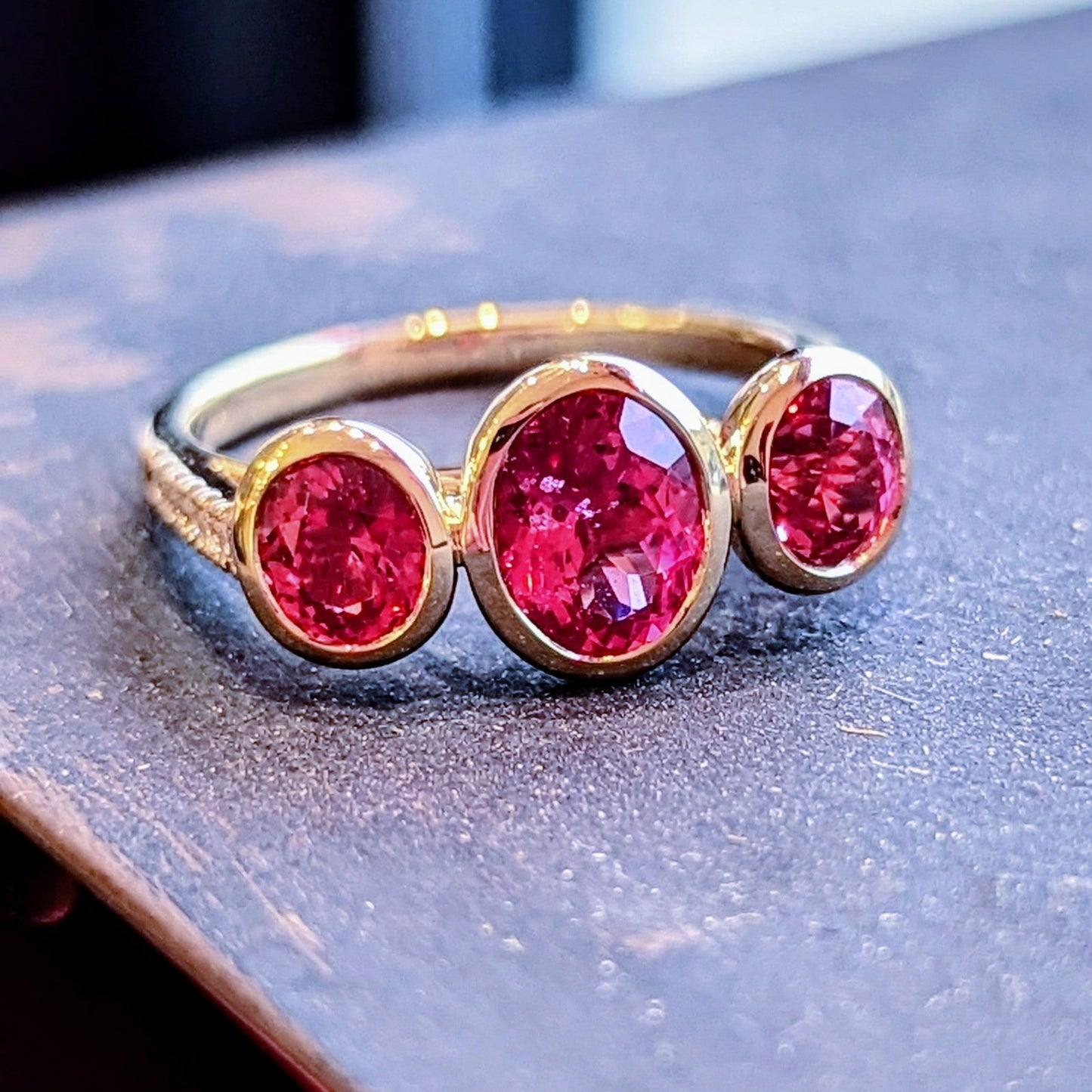 Photo of Mahenge Spinel Stackable 3-Stone Ring in a decorative scene, designed by , available at Plumb Gold & Plumb Silver