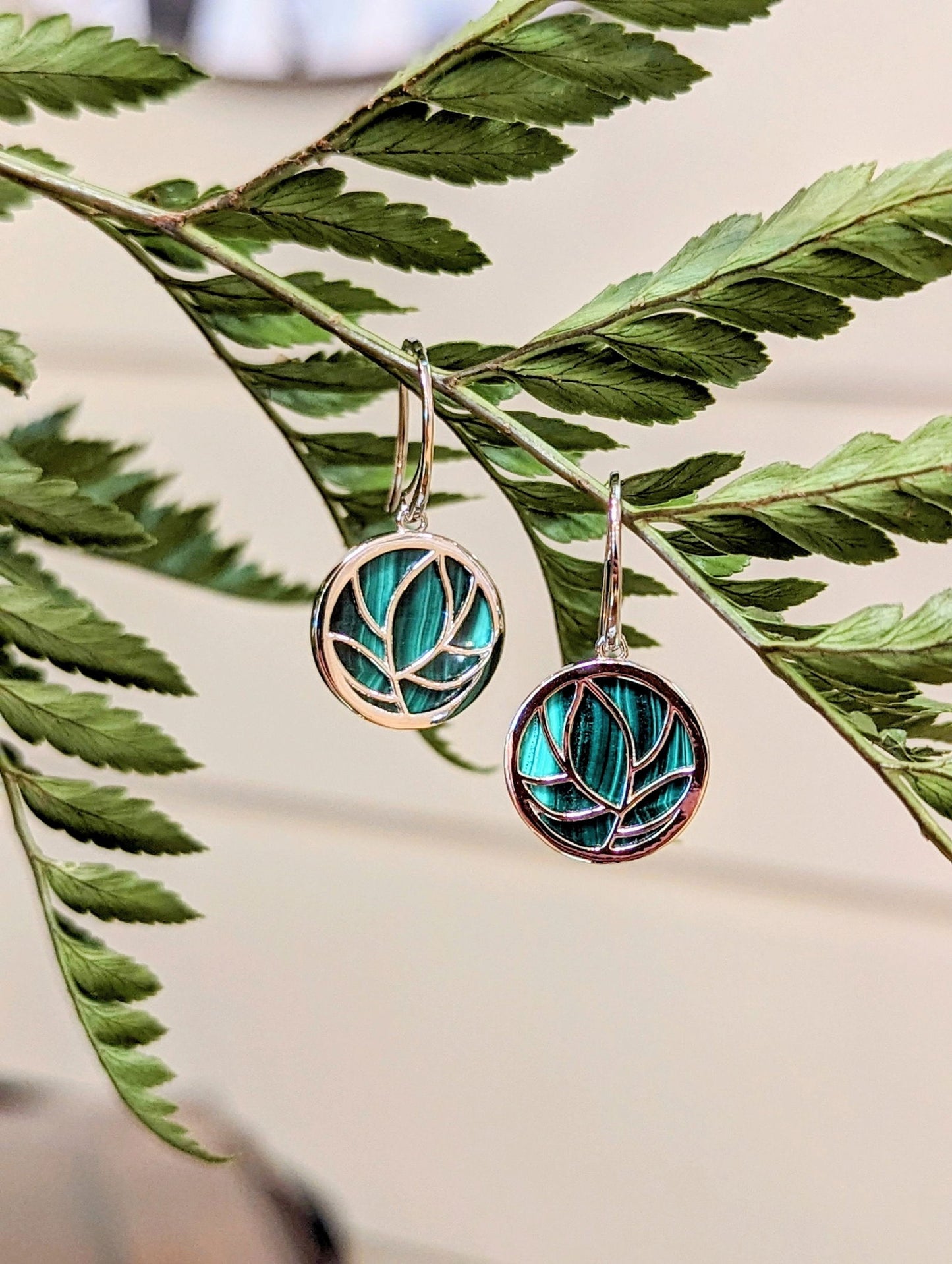 Photo of Malachite Drop Earrings in a decorative scene, designed by , available at Plumb Gold & Plumb Silver