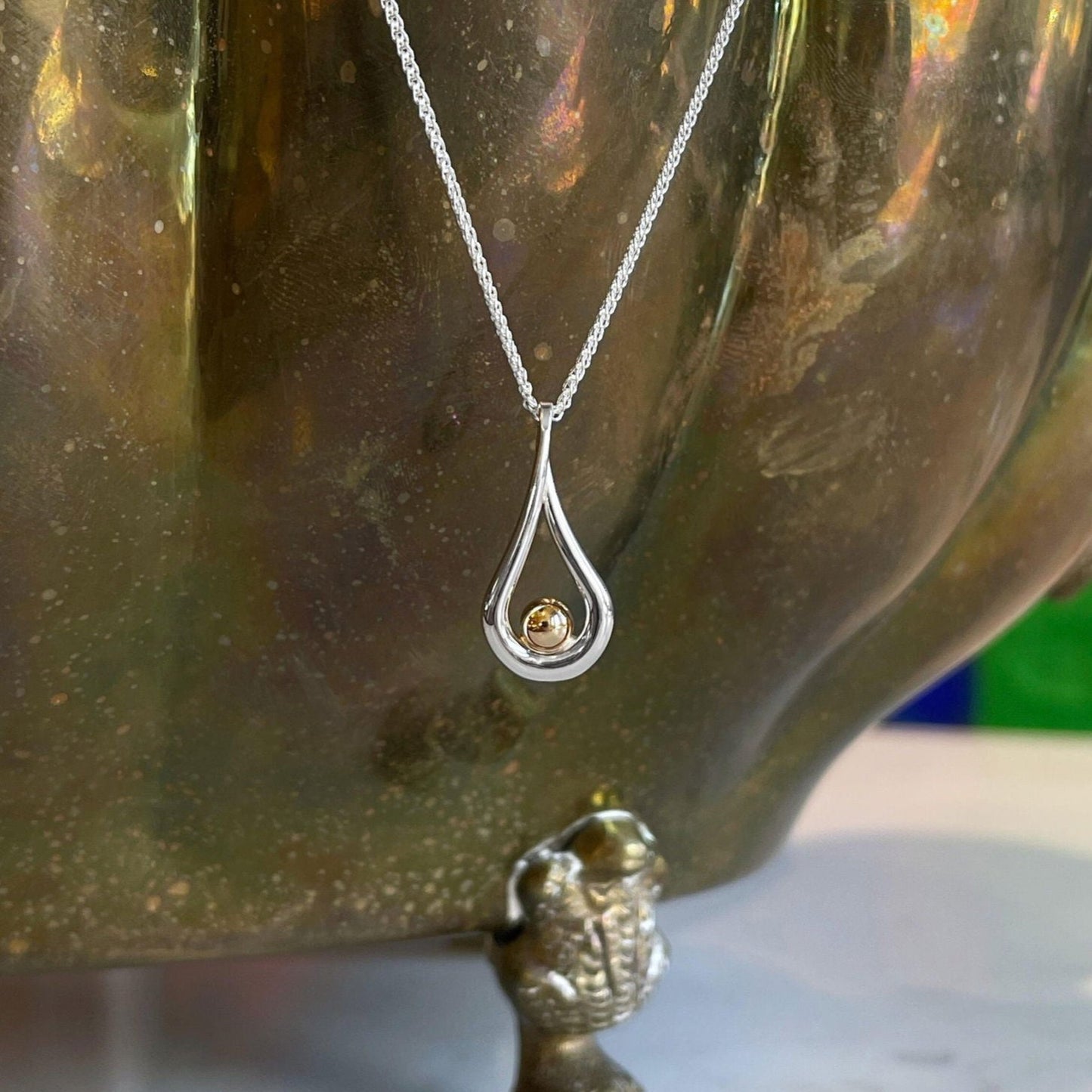 Photo of "Mana" Necklace in a decorative scene, designed by , available at Plumb Gold & Plumb Silver
