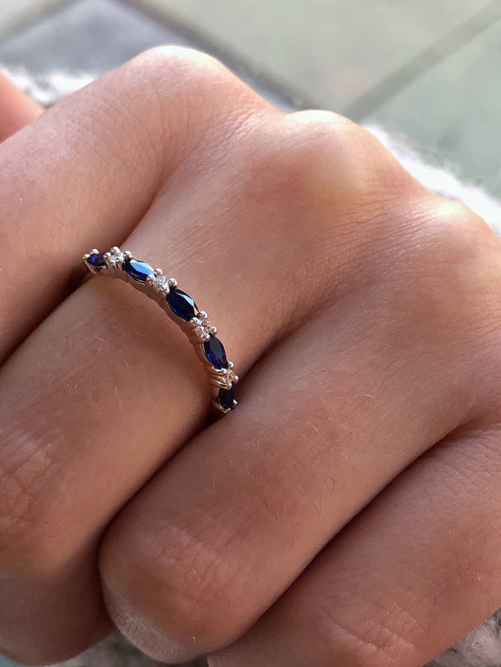 Photo of Marquise Sapphire Band in a decorative scene, designed by , available at Plumb Gold & Plumb Silver