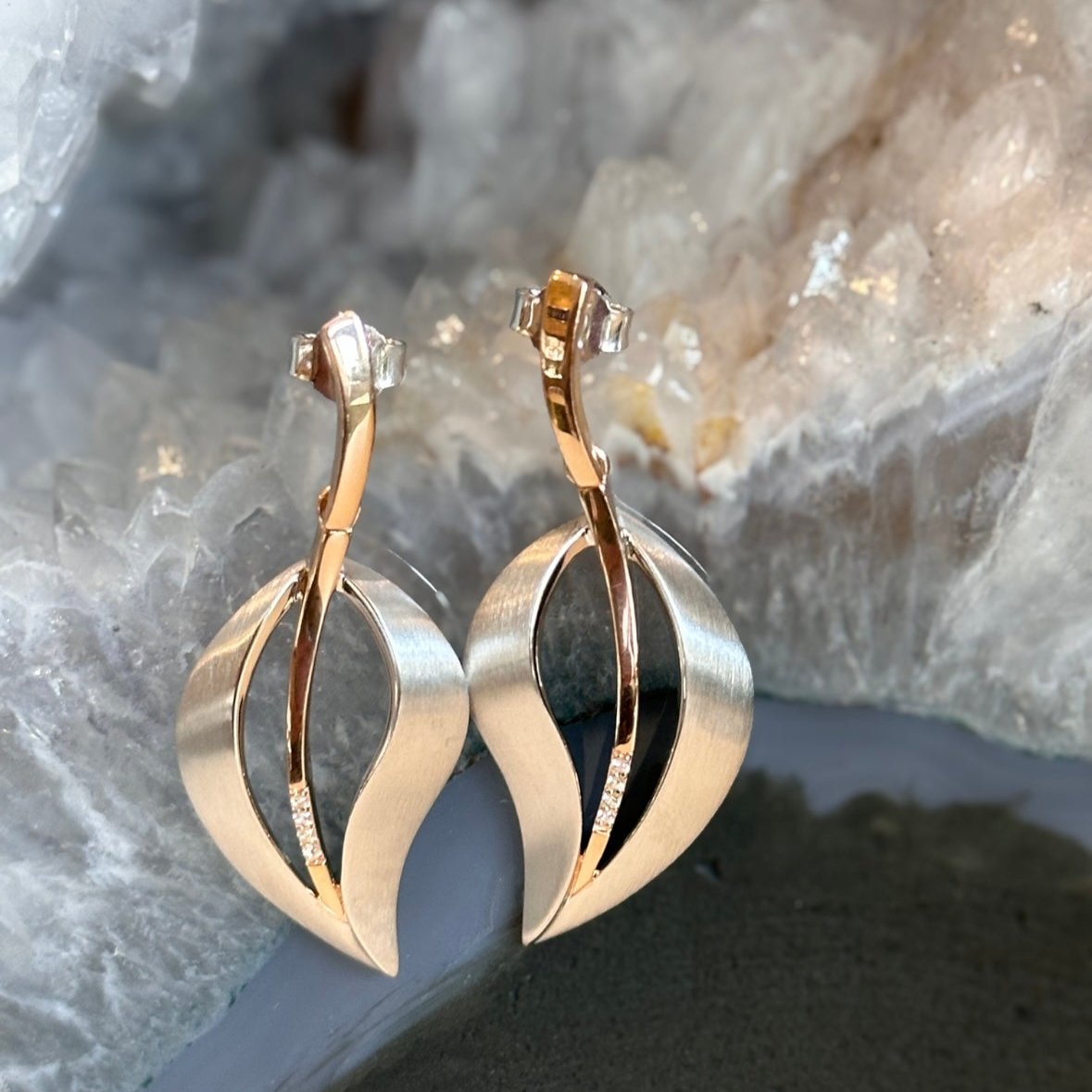 Photo of Matte Silver Leaf Earrings in a decorative scene, designed by , available at Plumb Gold & Plumb Silver