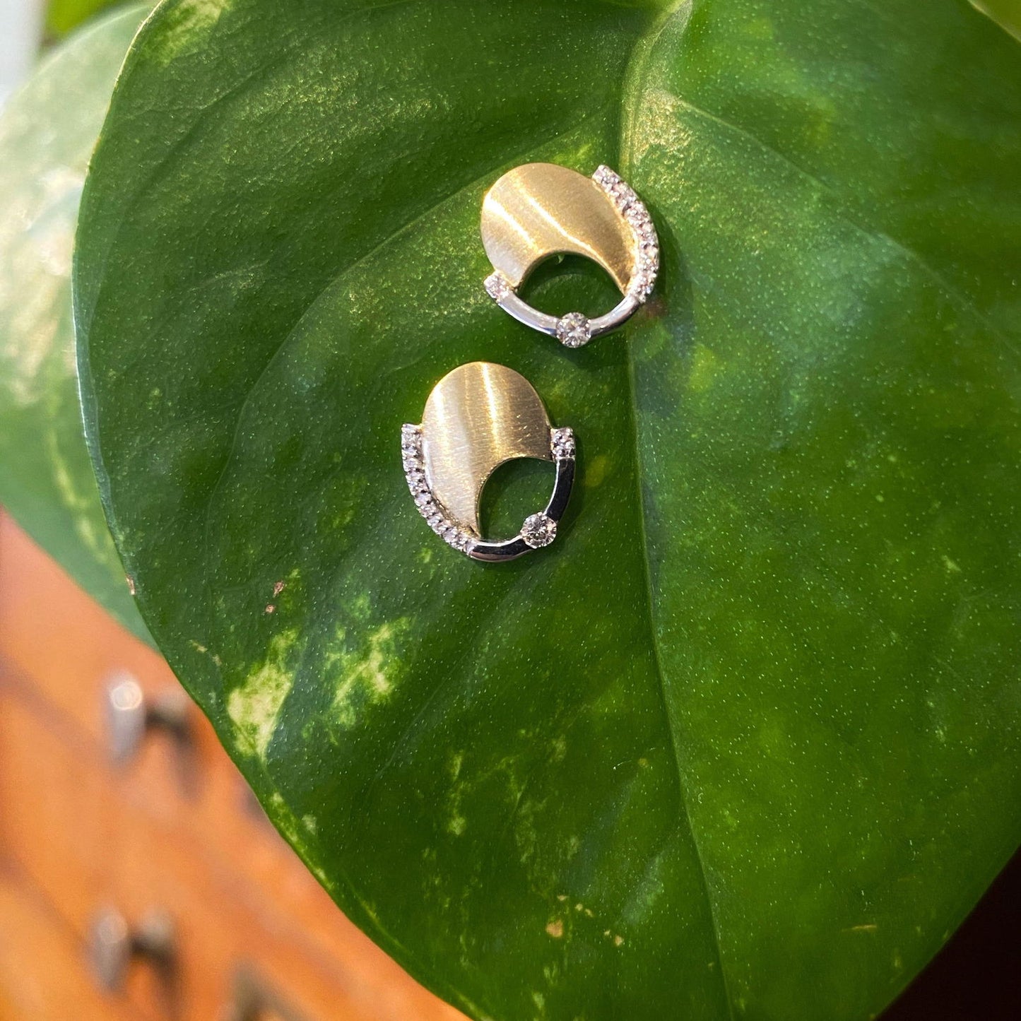 Photo of Matte crescent Oval Stud Earrings in a decorative scene, designed by , available at Plumb Gold & Plumb Silver