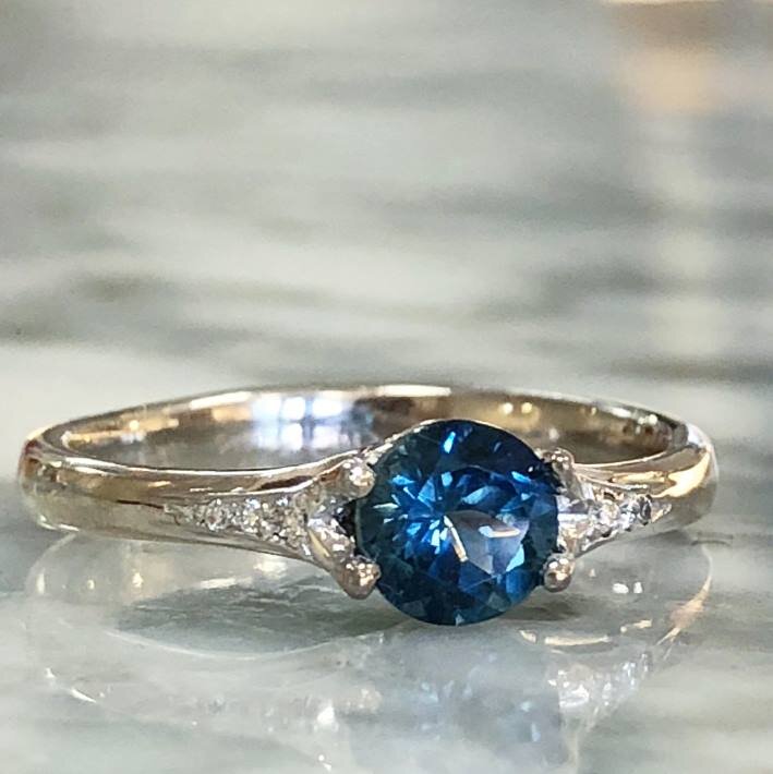 Photo of Montana Blue Sapphire Ring in a decorative scene, designed by , available at Plumb Gold & Plumb Silver