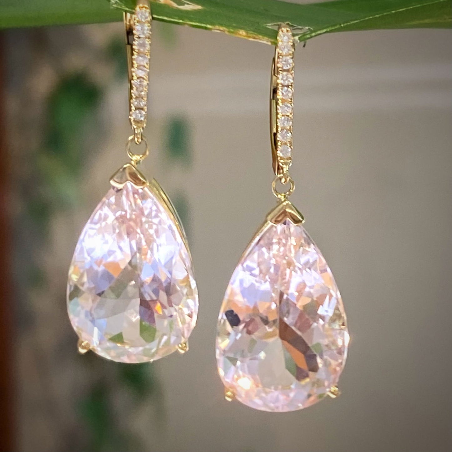 Photo of Morganite Pear Drop Earrings in a decorative scene, designed by -, available at Plumb Gold & Plumb Silver