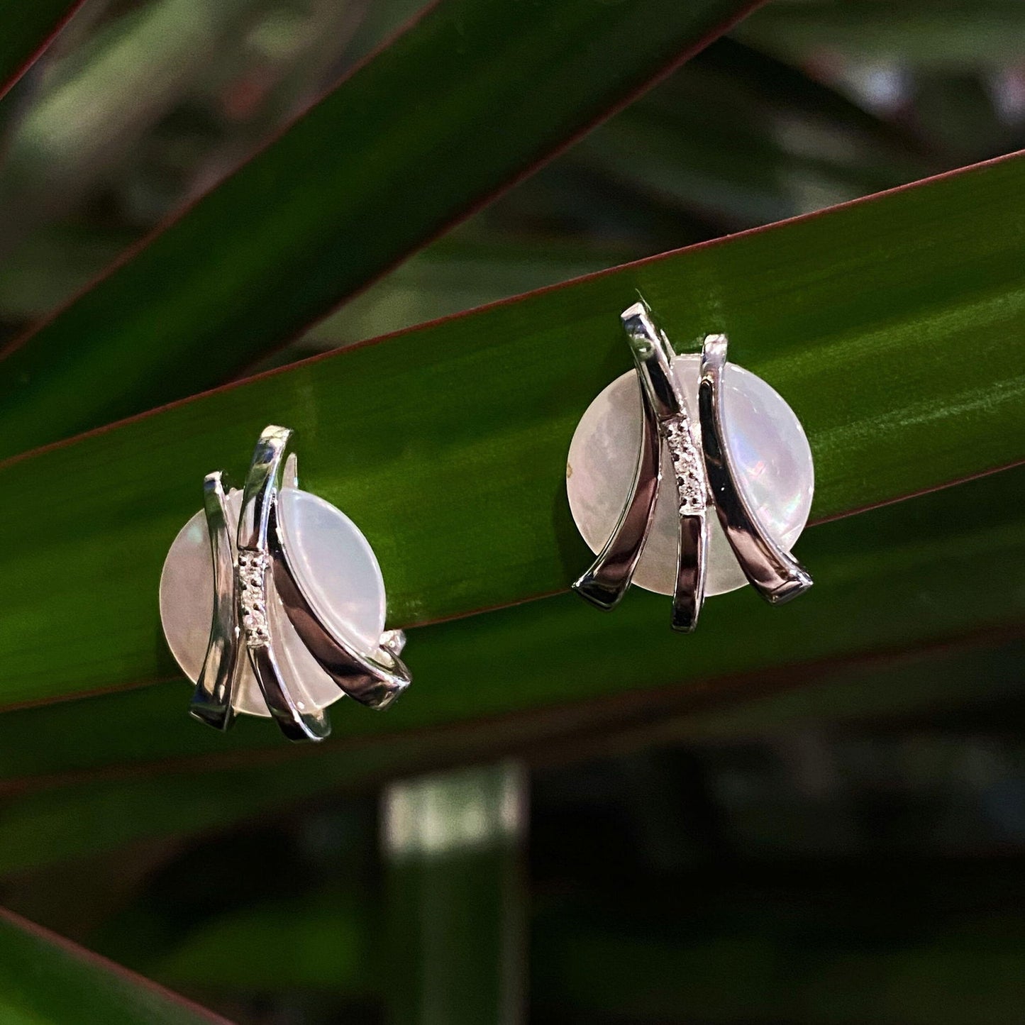 Photo of Mother of Pearl and Diamond Earrings in a decorative scene, designed by , available at Plumb Gold & Plumb Silver