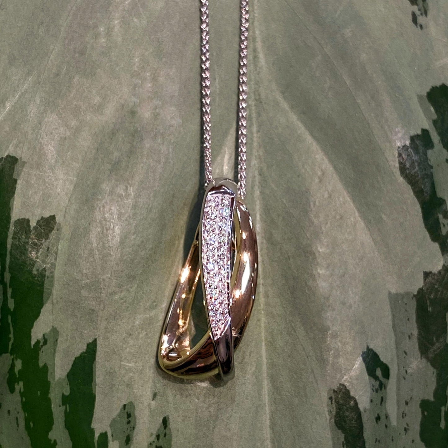 Photo of Multi-Crossover Pendant in a decorative scene, designed by , available at Plumb Gold & Plumb Silver