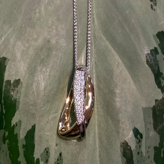 Photo of Multi-Crossover Pendant in a decorative scene, designed by , available at Plumb Gold & Plumb Silver