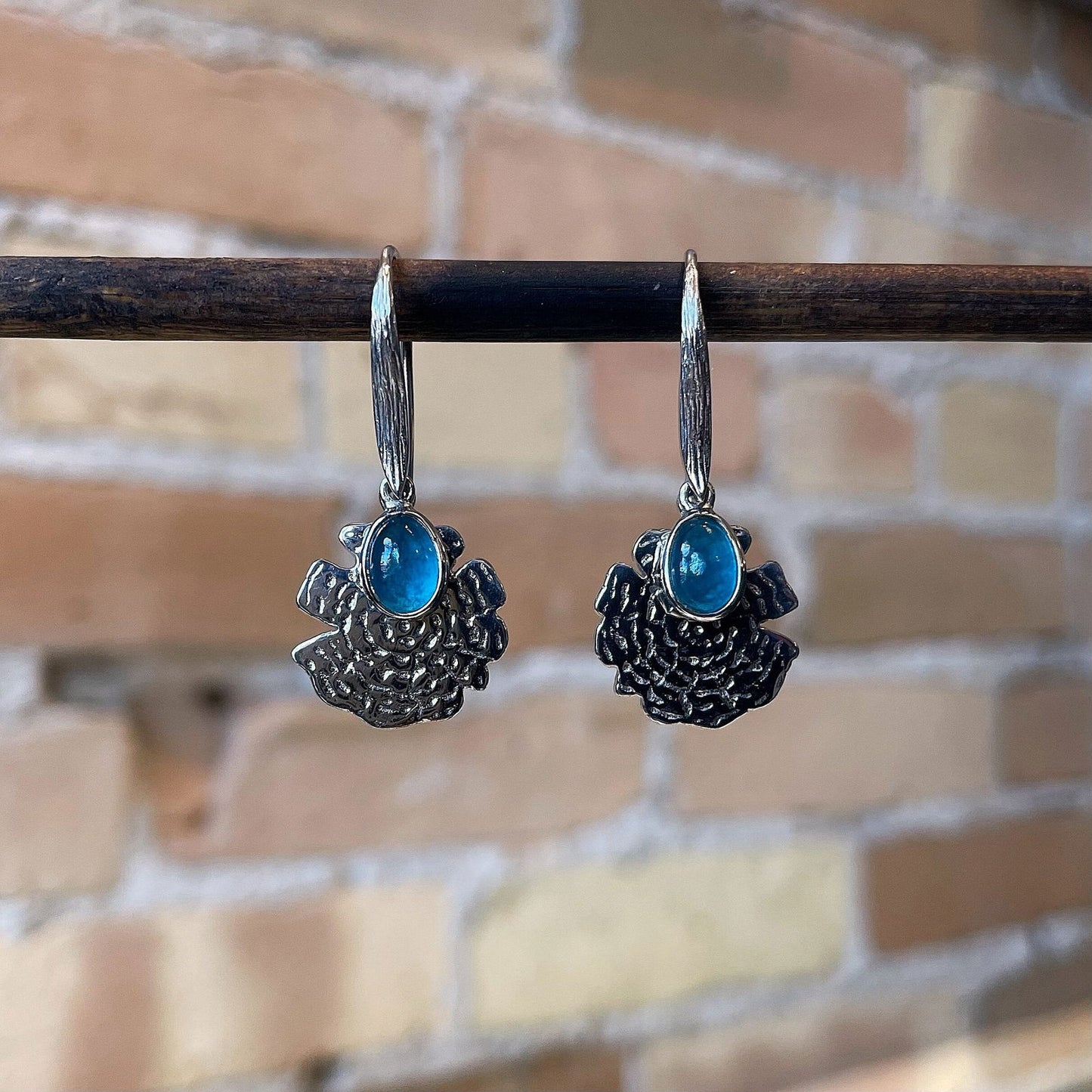 Photo of “Oak” Apatite Dangles in a decorative scene, designed by , available at Plumb Gold & Plumb Silver