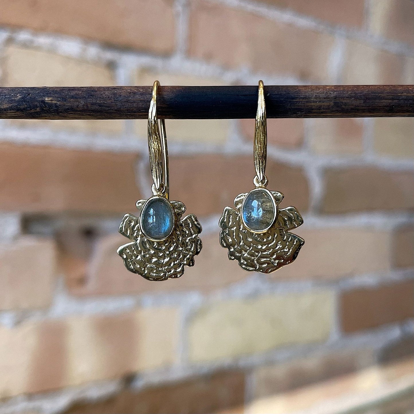 Photo of “Oak” Labradorite Dangles in a decorative scene, designed by , available at Plumb Gold & Plumb Silver