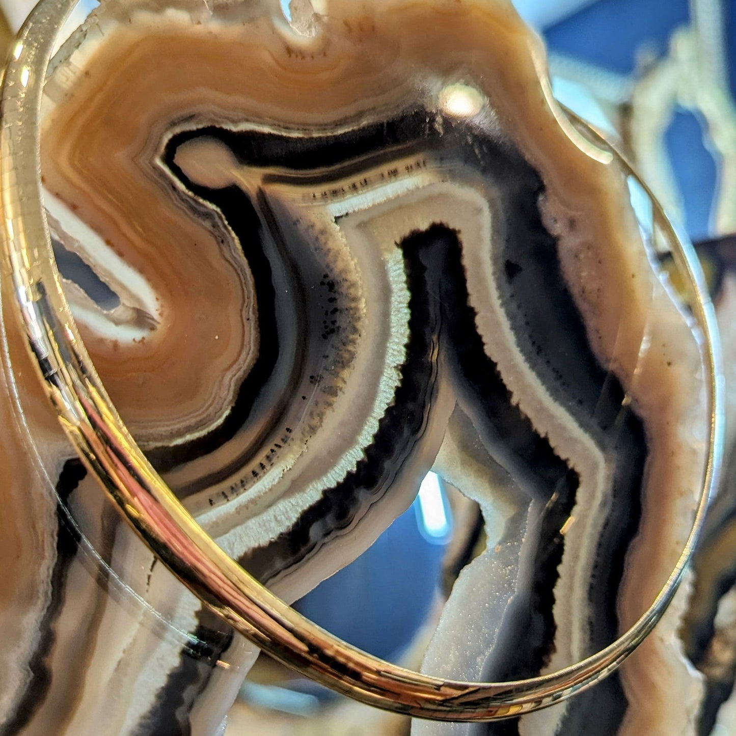 Photo of Omega Necklace in a decorative scene, designed by , available at Plumb Gold & Plumb Silver