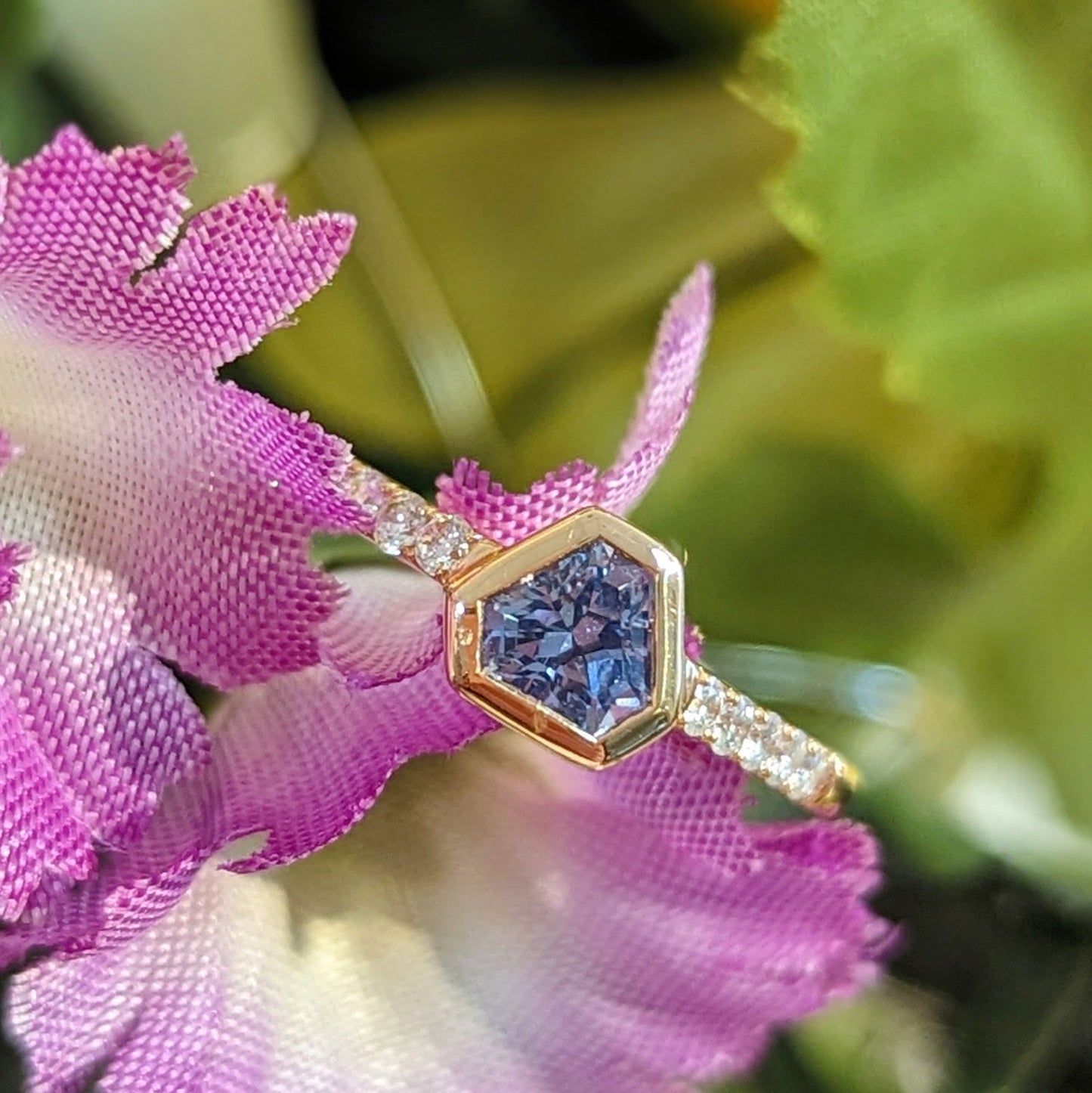 Photo of One of a Kind Blue Saphire Shield Stackable ring in a decorative scene, designed by , available at Plumb Gold & Plumb Silver