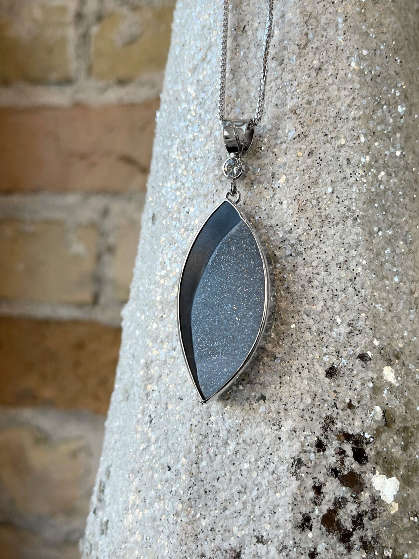 Photo of Onyx and Druzy Pendant in a decorative scene, designed by , available at Plumb Gold & Plumb Silver