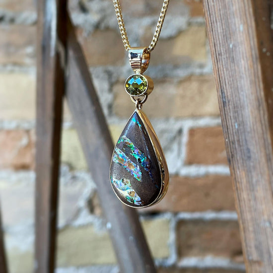 Photo of Opal and Peridot Pendant in a decorative scene, designed by , available at Plumb Gold & Plumb Silver