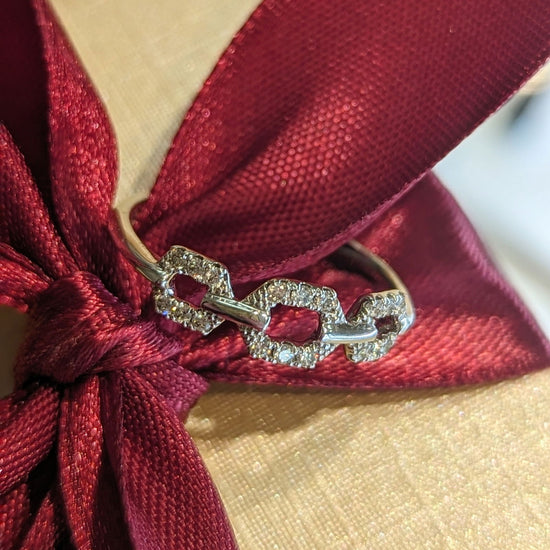 Photo of Open Hexagon Diamond Ring in a decorative scene, designed by , available at Plumb Gold & Plumb Silver