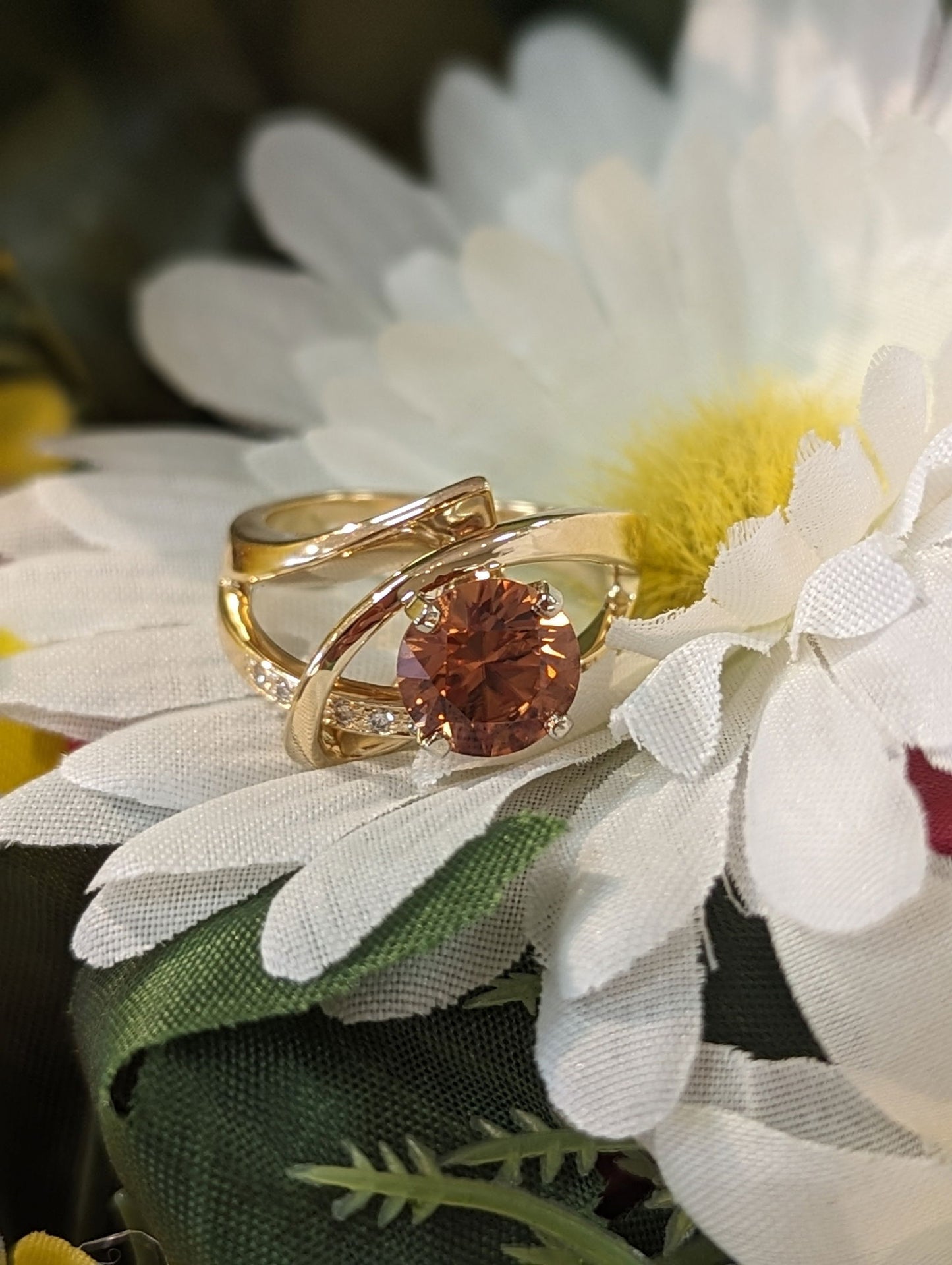 Photo of Orange Zircon and Diamond Ring in a decorative scene, designed by , available at Plumb Gold & Plumb Silver