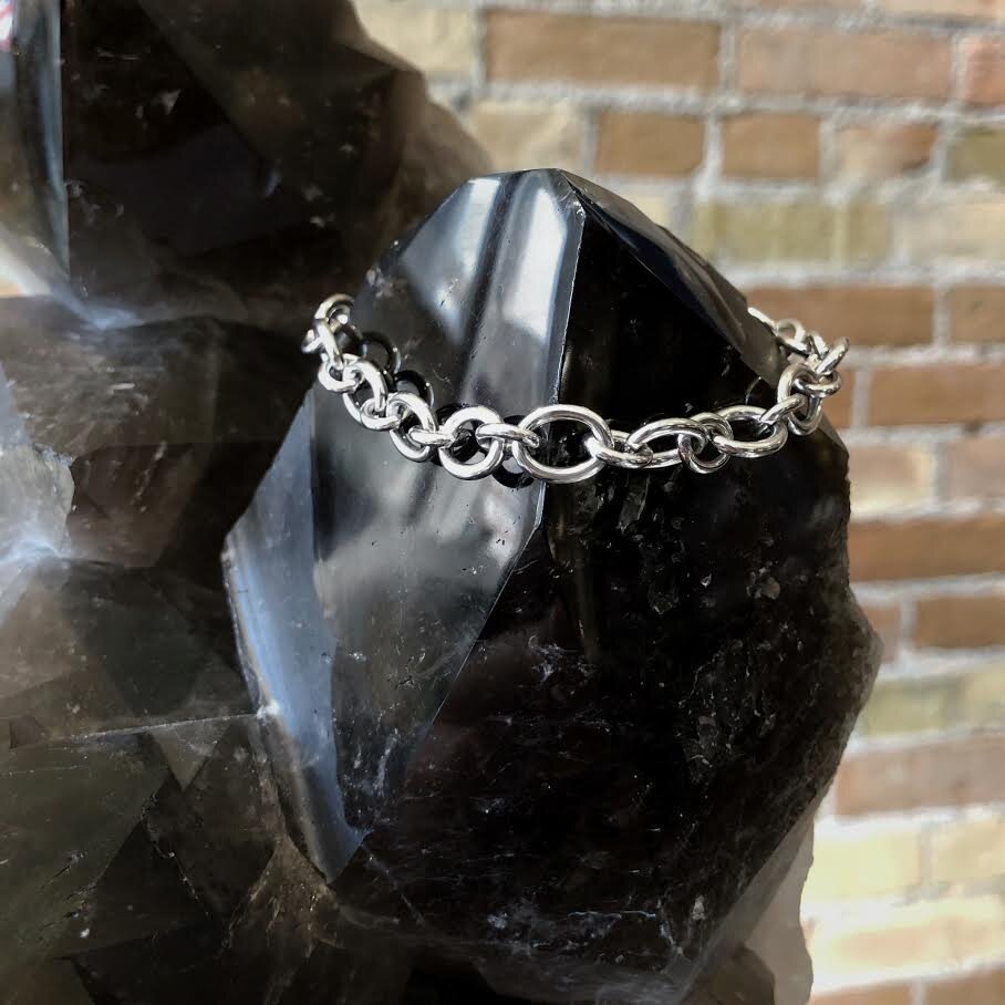Photo of Oval Cable Bracelet in a decorative scene, designed by , available at Plumb Gold & Plumb Silver
