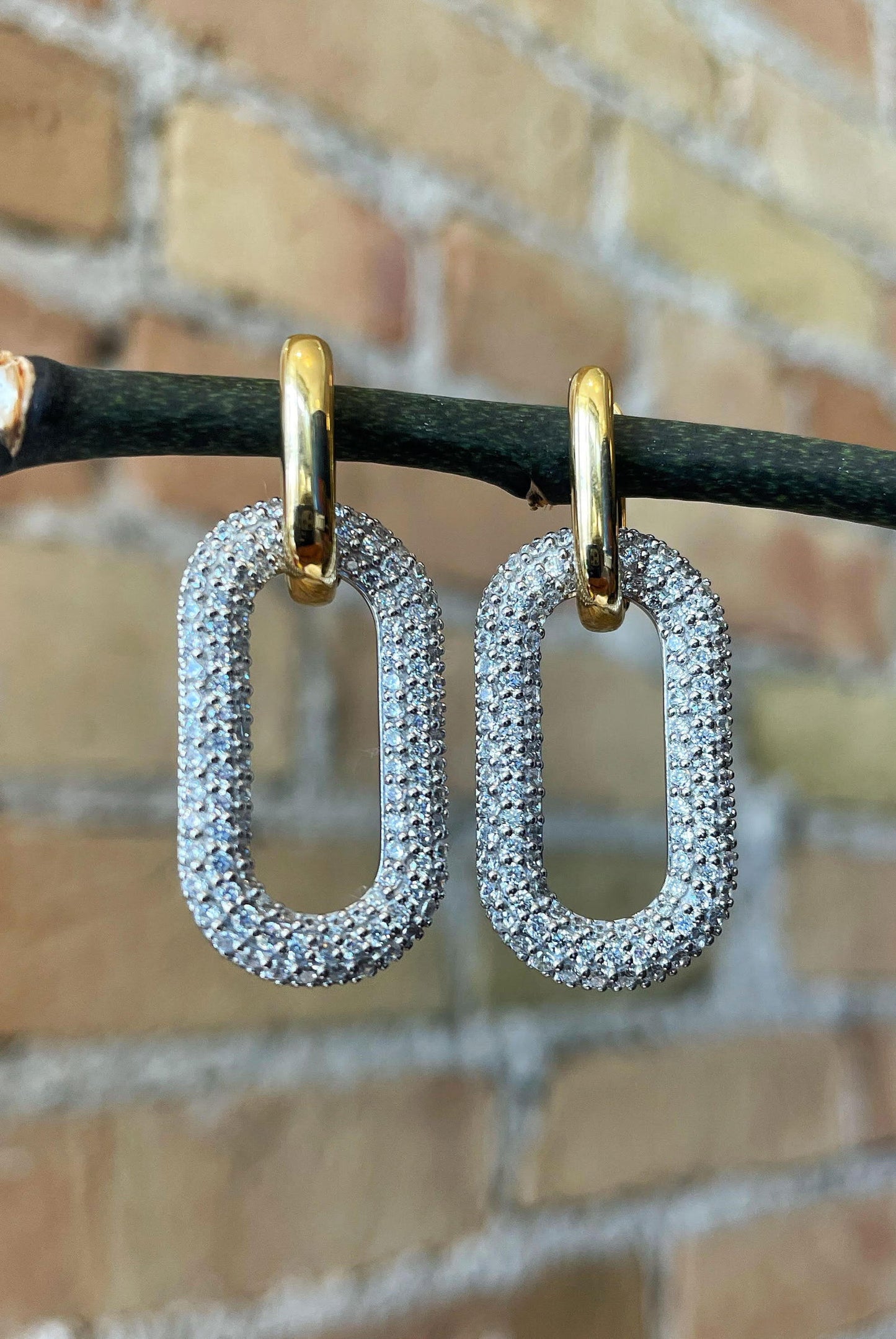 Photo of Paper Clip Cubic Zirconia Earrings in a decorative scene, designed by , available at Plumb Gold & Plumb Silver